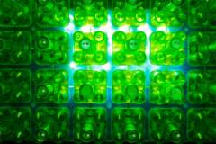Green plastic rack holding transparent test tubes, angled with caps visible against a white background Green plastic rack holding transparent test tubes, angled with caps visible against a white background