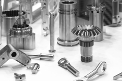 Various MIM (Metal Injection Molding) parts, including gears and shafts, showcasing diverse components