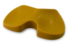 Precision-machined yellow polymer tibial spacer with a contoured design used in knee replacement surgery